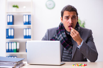 Young male employee suffering at workplace