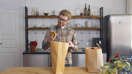 Young Man Returning Home With Shopping Bags