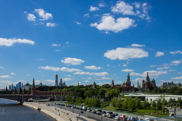 Fototapeta na wymiar panoramic view of the brick wall and the Kremlin towers and skyscrapers of Moscow city in the background on the blue sky and the Moscow river on a clear summer day