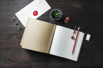Blank open book and vintage stationery on wood table background. Flat lay.