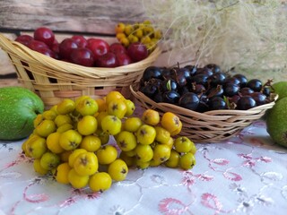 Food fruit and berry still life cherry in a basket black currant in a basket plate unripe yellow rowan green walnuts
