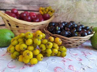 Food fruit and berry still life cherry in a basket black currant in a basket plate unripe yellow rowan green walnuts