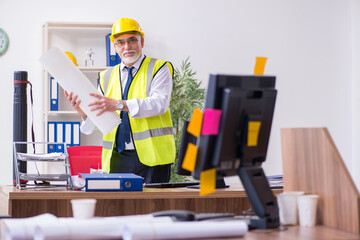 Old male architect working in the office