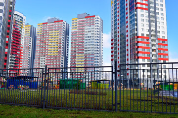 The fence and in the distance new buildings, residential complex