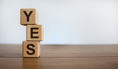Wood cubes with word 'yes' on wooden table, beautiful white background, copy space. Business concept.