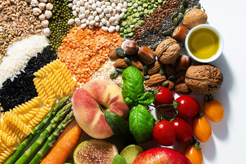 basic vegan ingredients and products. cereals, legumes, fresh vegetables and fruits, oils, seeds and nuts. balanced healthy diet isolated on white