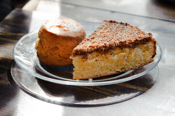 scone and cake for breakfast or snack on a glass plate on rustic wood table
