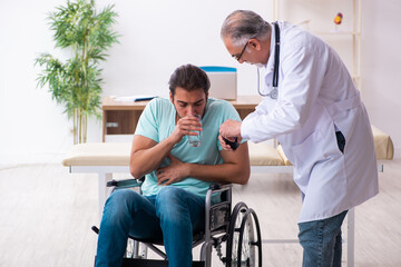 Experienced doctor and young male patient in wheel-chair