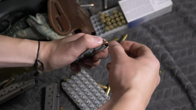 60p/slomo: Top down shot of Unloading Semi-Automatic Handgun Magazine