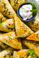 indian samosa made with phyllo with spicy potatoes and vegetables , served with yogurt, mint and lemon. close up for advertising