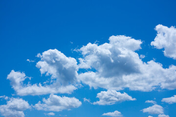 Perfect blue sky with fluffy white clouds in diagonally formation