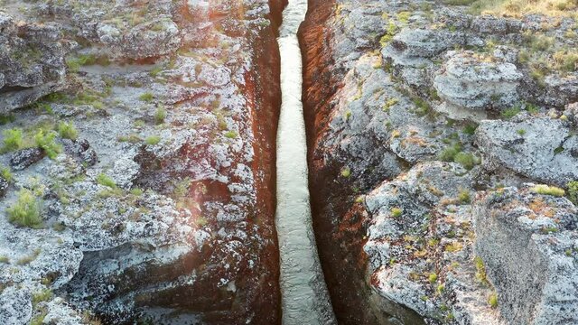 Narrow mountain river flowing through rocky landscape. Stream bed cut deep into stones. Upstream of Cijevna (Cem) in Montenegro. Aerial footage.