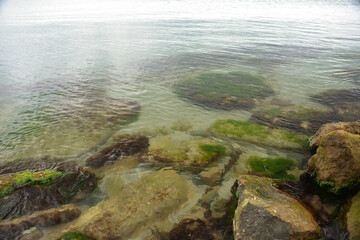 calm sea, small waves, clear and transparent water, small sand near the shore