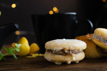 tipico alfajor cordobés de argentina y alfajor de maicena con dulce de leche con cafe al paso, limón menta medialunas  sobre madera con fondo oscuro © patoouupato
