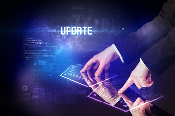 Hand touching digital table with UPDATE inscription, new age security concept