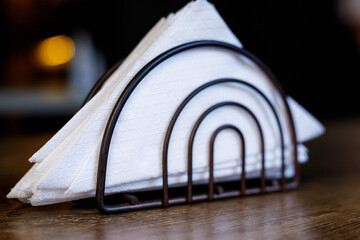 iron black stand with white napkins stands on the table, institution, cafe, serving details, rest, cleanliness, etiquette