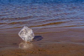 Plastic on the beach close-up. Environmental pollution. Plastic bottle washed up on the beach, marine pollution.