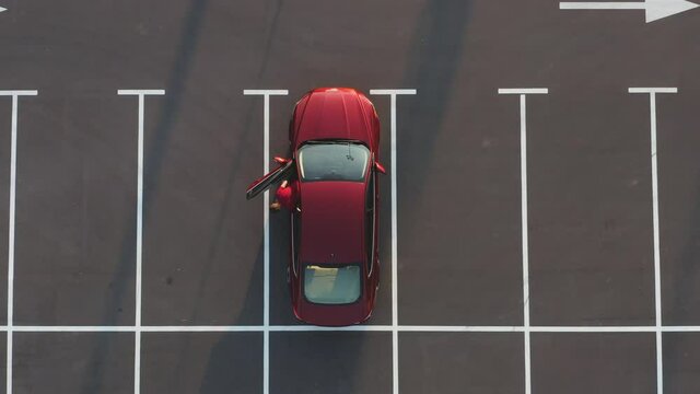 The man gets out of the car on the empty parking lot