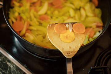 A spatula for cooking with an image in the form of a smiley face made of carrots