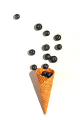 Summer fruits creative flat lay. Raspberry in ice cream cone on waffle cup on white background. Summer sweet menu concept.