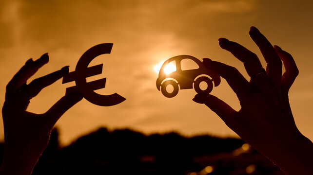 Euro symbol and car in women's hands contoured at sunset