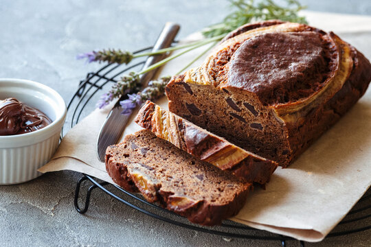 banana bread with chocolate and nutella on grey background with lavender flowers