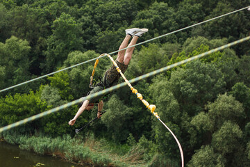Concept of Extreme Sports and Fun. One  man is a  thrill-seeker and a  rope jumper from the bridge....