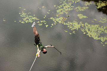 Concept of Extreme Sports and Fun. One  man is a  thrill-seeker and a  rope jumper from the bridge....