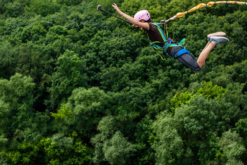 Ivanovsky Bridge, Ukraine - June 21, 2020: Concept of Extreme Sport. The  girl is  doing rope...
