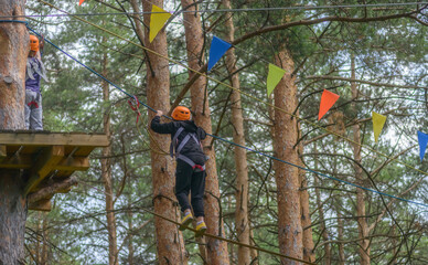 hildren climbing trees. Rope park. Child is a climber. Cables are installed. Balancer and rope bridges. Rope Park-mountaineering center of the forest Park. Russia. Tatarstan. 01. 07. 2020