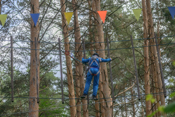 hildren climbing trees. Rope park. Child is a climber. Cables are installed. Balancer and rope bridges. Rope Park-mountaineering center of the forest Park. Russia. Tatarstan. 01. 07. 2020