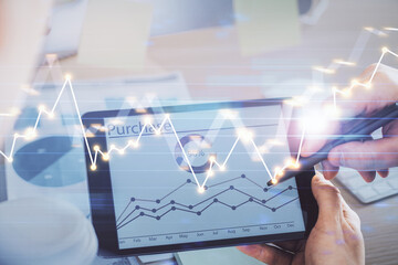 Double exposure of man's hands holding and using a phone and financial chart drawing. Market analysis concept.