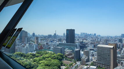 Fototapeta na wymiar 青空を背景に文京区から見た新宿方面のビル群と小石川後楽園の緑