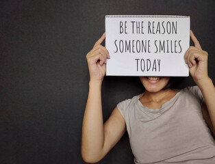 BE THE REASON SOMEONE SMILES TODAY text written on paper. Stock photo.