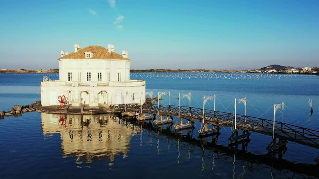 Casina Vanvitelliana and Fusaro lake, little house located in Italy, wooden bridge and small island of Bacoli, the building is reflected in the water