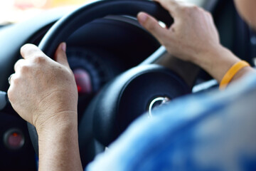 Cropped closeup shot of the hands of a man on a steering wheel. selective focus