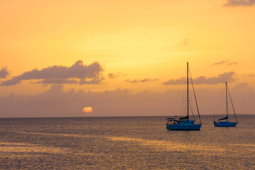 Naklejka premium Sunset behind sailboats in the Caribbean