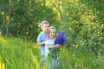 Fototapeta premium Little boy hugs a girl on the nature in summer