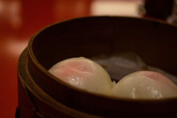 中華セイロに盛られた桃まんじゅうのクローズアップ