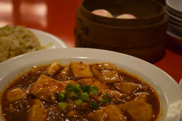 中華料理店の赤いテーブルに置かれた麻婆豆腐