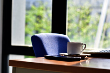 Cup of coffee ,smartphone and notebook on a wooden table. Simple workspace or coffee break in the morning.