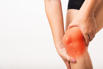 Closeup young Asian woman joint holding her painful knee, studio shot isolated on white background,...