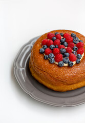 Savarin cake, a kind of rum baba, with custard cream and fresh berries. Isolated on white background.