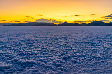 Bonneville Salt Flats colorful purple dark twilight mountains silhouette open low angle ground level view after sunset near Salt Lake City, Utah with clouds