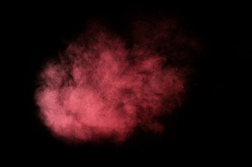 Red and pink powder explosion on black background. Colored powder cloud. Colorful dust explode. Paint Holi.