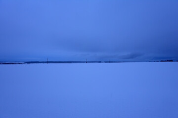 snow-covered expanse of field with trees