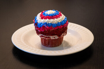 Patriotic homemade chocolate cupcake with American colors, red, white, and blue icing, for Fourth of July (American Independence Day).