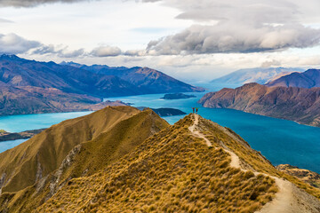 New Zealand hiking people on mountain top Roys Peak enjoying active outdoor lifestyle arms raised...