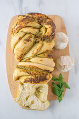 home made braided basil pesto bread on a table