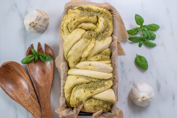 home made braided basil pesto bread on a table